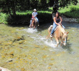 horseback riders crossing a stream near Jackson Hole Wyoming